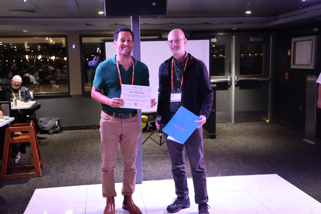 Picture of Dr. Nathaniel Hudson receiving the best paper award at the 2025 e-Science conference.